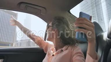 这个女孩正在用一部来自迪拜的电话从一辆汽车上直播。